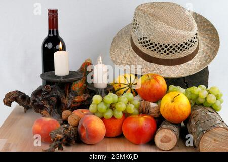Ein herbstliches Stillleben mit Früchten, Hut und Wein Stockfoto
