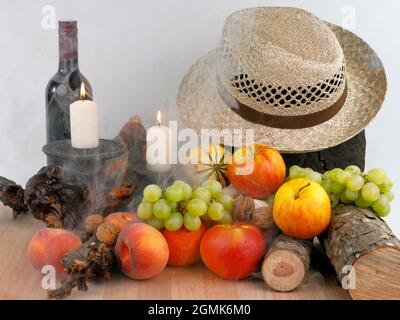 Ein herbstliches Stillleben mit Früchten, Hut und Wein Stockfoto