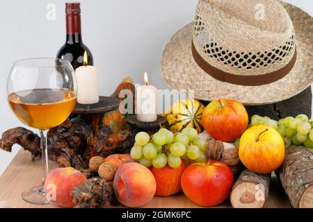 Ein herbstliches Stillleben mit Früchten, Hut und Wein Stockfoto