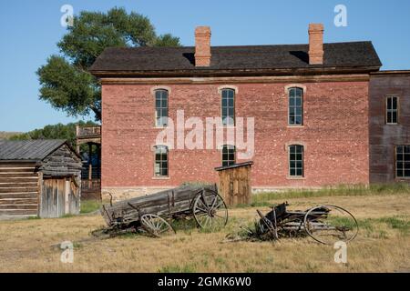 Alte Holzwaggons, die in einem Feld neben dem Hotel Meade in der Geisterstadt Bannack State Park, Montana, USA, in Verfall sind Stockfoto