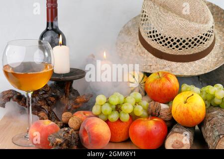 Ein herbstliches Stillleben mit Früchten, Hut und Wein Stockfoto