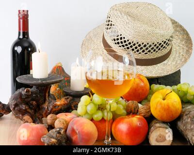 Ein herbstliches Stillleben mit Früchten, Hut und Wein Stockfoto