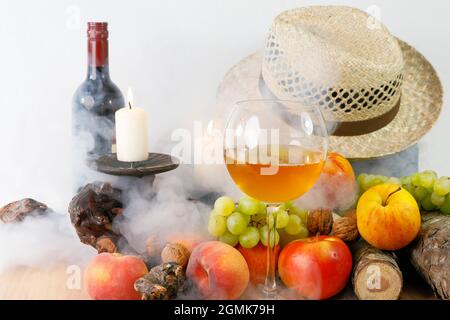 Ein herbstliches Stillleben mit Früchten, Hut und Wein Stockfoto
