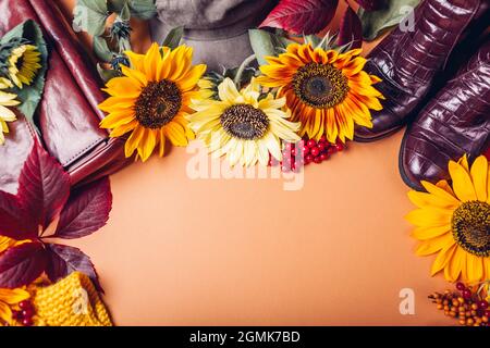 Draufsicht auf Herbst-Damenmode in orange-gelb-roten Farben mit Blumen. Kleidung Schuhe Accessoires. Verkaufs- und Einkaufskonzept Stockfoto