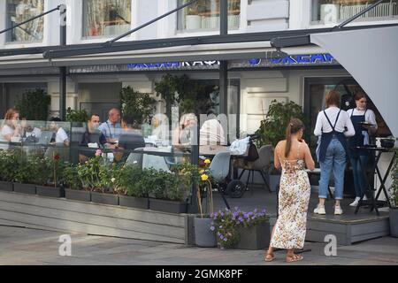 Moskau, Russland - am 31. August 2021 essen die Menschen an einem sonnigen Tag in einem Straßencafé auf einer Veranda im Stadtzentrum zu Mittag. Kusnetsky Most Stockfoto