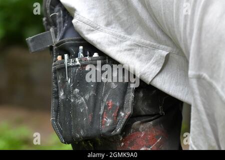 Nahaufnahme der Arbeitshose eines Malers oder Arbeiters, der Renovierungen oder Verbesserungen in seinem Haus unternimmt Stockfoto