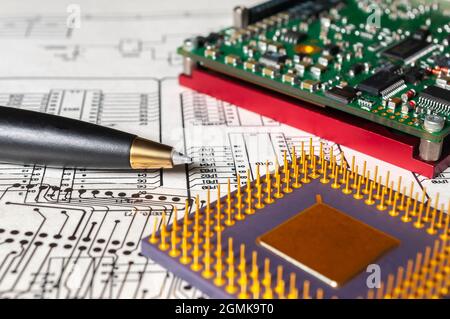 Elektronik, Stift, Prozessor und Funkkomponenten liegen auf dem Hintergrund eines Schaltplans und einer Fotomasken für die Herstellung von PR Stockfoto