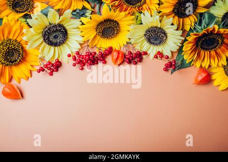 Herbst Herbst floralen Hintergrund. Bund gelber orangefarbener Limettensonnenblumen mit roten Beeren und Samenschoten. Platz Stockfoto