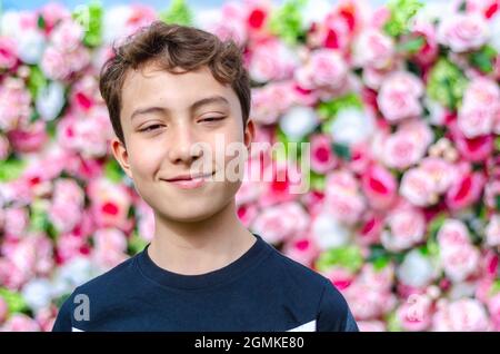 Ein Porträt eines Jungen, der auf einen langsameren Wandhintergrund geschossen wurde. Stockfoto