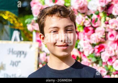 Ein Porträt eines Jungen, der auf einen langsameren Wandhintergrund geschossen wurde. Stockfoto