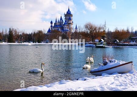 Blue Retro Märchenschloss am Seeufer im Winter unter Schnee und Schwimmen Schwäne am See Eskisehir Türkei Stockfoto