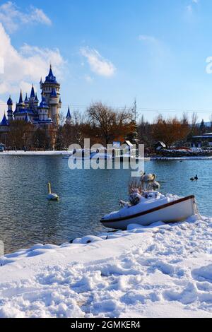 Blue Retro Märchenschloss am Seeufer im Winter unter Schnee und Schwimmen Schwäne am See Eskisehir Türkei Stockfoto