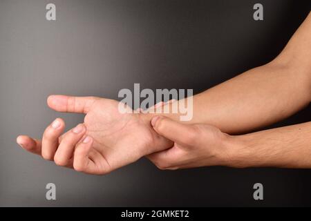 Akupressur, Selbstbehandlung durch die Hand, Akupressur auf schwarzem Hintergrund Stockfoto