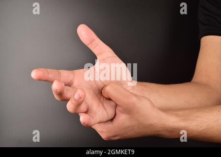 Mann macht Selbstaufdruck auf dunklem Hintergrund Stockfoto