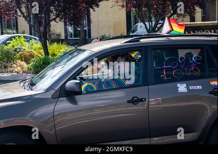 Die Teilnehmer winken aus einem Auto mit einem Spruchband mit den Aufsagen „Liebe ist Liebe“, „Schwarze Leben“ und mehr nehmen an einer Veranstaltung der Placer County Pride-Karawane Teil Stockfoto