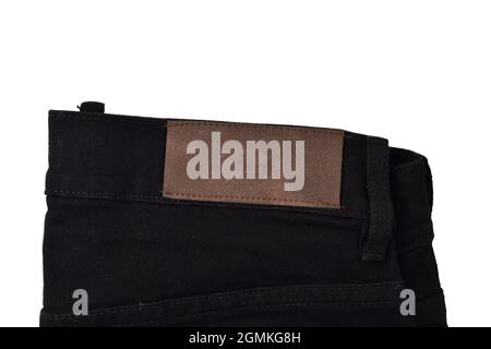 Lederfarbenes Label auf schwarzer Denim-Jeans isoliert auf weißem Hintergrund Stockfoto