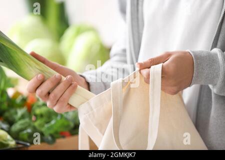 Junger Mann, der Gemüse auf dem Markt wählt Stockfoto