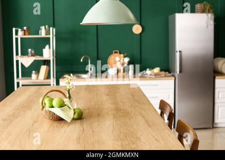 Interieur der stilvollen Küche mit grünen Äpfeln auf dem Esstisch Stockfoto