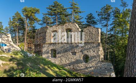 Luftaufnahme der mittelalterlichen Blatnica gotische Burgruine auf einem Hügel über dem Dorf in einem üppig grünen Waldgebiet mit Türmen und Restaurierungsarbeiten in der Slowakei Stockfoto