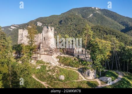 Luftaufnahme der mittelalterlichen Blatnica gotische Burgruine auf einem Hügel über dem Dorf in einem üppig grünen Waldgebiet mit Türmen und Restaurierungsarbeiten in der Slowakei Stockfoto