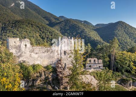 Luftaufnahme der mittelalterlichen Blatnica gotische Burgruine auf einem Hügel über dem Dorf in einem üppig grünen Waldgebiet mit Türmen und Restaurierungsarbeiten in der Slowakei Stockfoto