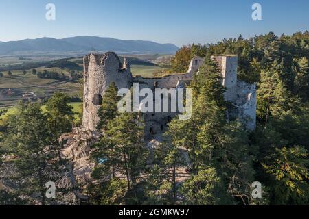 Luftaufnahme der mittelalterlichen Blatnica gotische Burgruine auf einem Hügel über dem Dorf in einem üppig grünen Waldgebiet mit Türmen und Restaurierungsarbeiten in der Slowakei Stockfoto