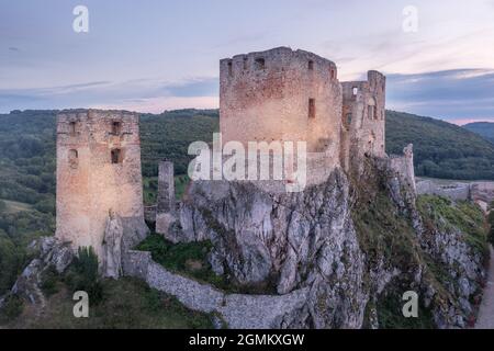 Luftaufnahme der gotischen Burgruine Csesznek in der Region Bakony in Ungarn in der Grafschaft Veszprem mit altem Palastgebäude, Torturm mit buntem dra Stockfoto