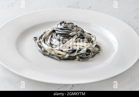 Porion von Tintenfisch Tinte Pasta mit cremiger Sauce Stockfoto