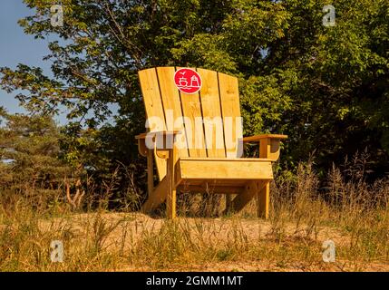 Großer Adirondack-Stuhl auf einer Sanddüne mit Blick auf den Lake Michigan Strand in Two Rivers, Wisconsin. Stockfoto