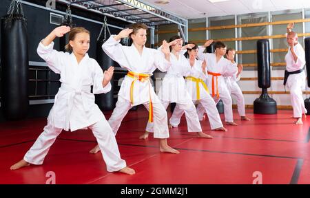 Karate Kids im Kimono, die Kata Moves ausführen Stockfoto