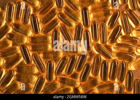 Fischöl auf goldenem Hintergrund .Omega-Fettsäuren.natürliche Nahrungsergänzungsmittel.gesunde Ernährung und Nahrungsergänzungsmittel.natürliche Nahrungsergänzungsmittel Stockfoto