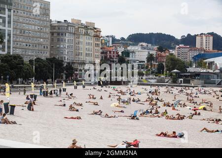 Coruna-Spanien. Blick auf den Strand von Riazor in La Coruña mit Badegästen und mehreren Behältern zum Recycling von Dosen und Müll am 12. September 2021 Stockfoto