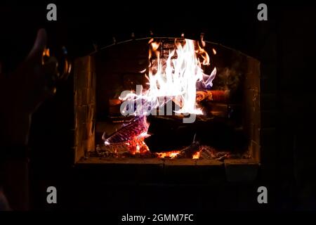 Blick auf die Flammen eines Feuers in einem Kamin mit trockenem Holz Stockfoto