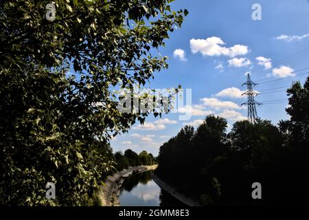 An einem sonnigen Tag in der italienischen Landschaft umgebener Kanal Stockfoto