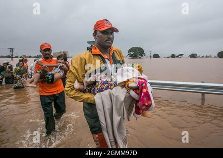 Die westliche Region des Bundesstaates Maharashtra wurde in kurzer Zeit von 225 % Niederschlägen getroffen, was zu Überschwemmungen in den Distrikten Kolhapur und Sangli führte. Kolhapur und Sangli wurden auch von ähnlichen Überschwemmungen in den Jahren 1989 und 2005 getroffen, aber dieses Mal brach es alle Grenzen, tötete mehr als 50 Menschen in 15 Tagen und verursachte massiven Schaden. Zum ersten Mal in der Geschichte wurde die NH4 Mumbai Bangalore Autobahn aufgrund von Hochwasser stillgelegt. Rettungseinsätze wurden vom Katastrophenmanagement-Team, dem NDRF und Armeepersonal durchgeführt, um Menschen aus den Dörfern Ambwewadi, Chikhali und Prayag Chikhali, 8 km von Kolhapur entfernt, zu evakuieren Stockfoto