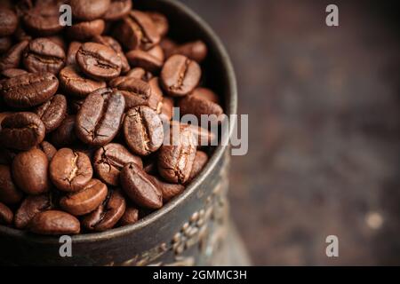 Kaffeebohnen auf dem rustikalen Holzhintergrund. Selektiver Fokus. Geringe Schärfentiefe. Stockfoto
