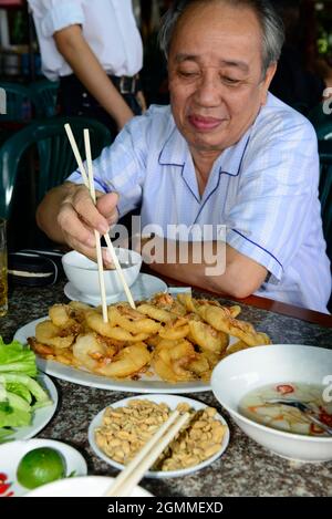 Banh Tom (vietnamesische frittierte Garnelenkuchen) ist ein beliebtes Gericht für Straßengerichte in Hanoi, Vietnam. Stockfoto