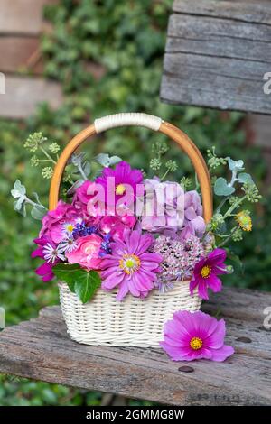 Bouquet von rosa Sommerblumen im Korb als florale Dekoration Stockfoto