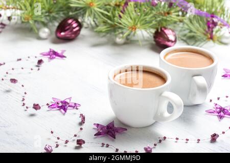 Zwei Tassen heißer Kakao und Weihnachtsdekorationen auf altem schäbigen Holzhintergrund. Stockfoto