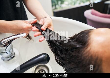Nahaufnahme von Kosmetologen tun Haarpflege Maske Stockfoto