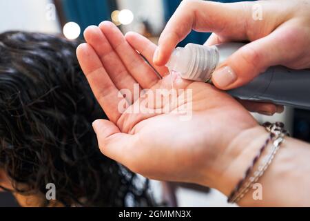 Nahaufnahme von Friseur Anwendung Lotion auf der Hand Stockfoto