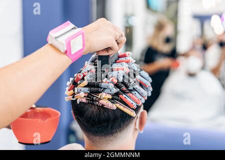 Hand eines Friseurs, der die Haare eines Mannes in einem Salon färben Stockfoto