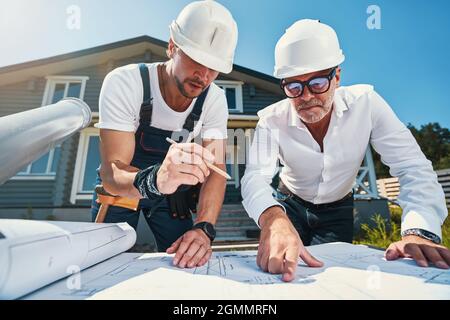 Zwei Ingenieure studieren Zeichnungen des Hauses Stockfoto