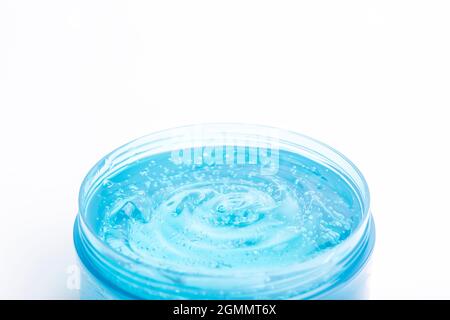 Kosmetisches Gel in einem Glas auf weißem Hintergrund. Blaues transparentes Gel mit Textur und Blasen isolieren. Hochwertige Fotos Stockfoto