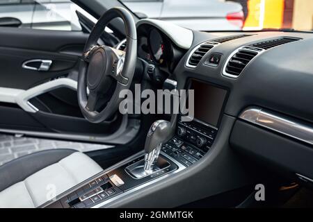 Blick auf den Innenraum des Luxus-Cabrios, modernes Armaturenbrett mit Touchscreen, weiße Ledersitze ideal für den Fahrer. Selektiver Fokus Stockfoto