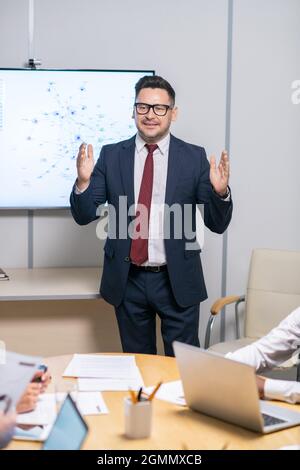 Erfolgreicher Trainer in formalwear, der dem Publikum die Punkte des Geschäftskurses erklärt Stockfoto