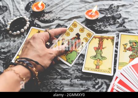 Zeig Wahrsagern von Händen, die Tarot-Karten halten und Tarot-Leser mit Kerzenlicht auf dem Tisch, Lesungen, magische Darbietungen, Dinge, die mein sind Stockfoto