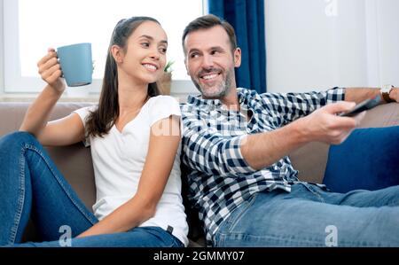 Paare, die Fernsehen auf dem Sofa sehen. Fernsehen, Multimedia, Freizeitkonzept Stockfoto