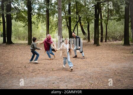 Happy muslim Mädchen spielen mit Eltern und Bruder im Park Stockfoto