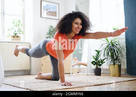 Junge Frau drinnen zu Hause, tun Übung. Sportkonzept. Stockfoto
